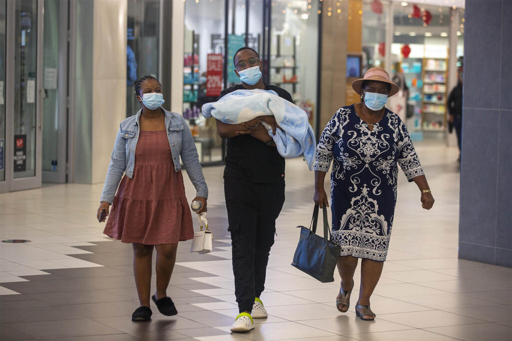 אנשים במסכות במרכז קניות ביוהנסבורג, דרום אפריקה (צילום: AP Photo/Denis Farrell)
