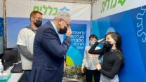 פרויקטור הקורונה, פרופ' סלמאן זרקא, משוחח עם הילדים דניאלה ונועם גמיש לפני החיסון במרכז החיסונים של כללית בסינמה סיטי בירושלים (צילום: דוברות כללית)