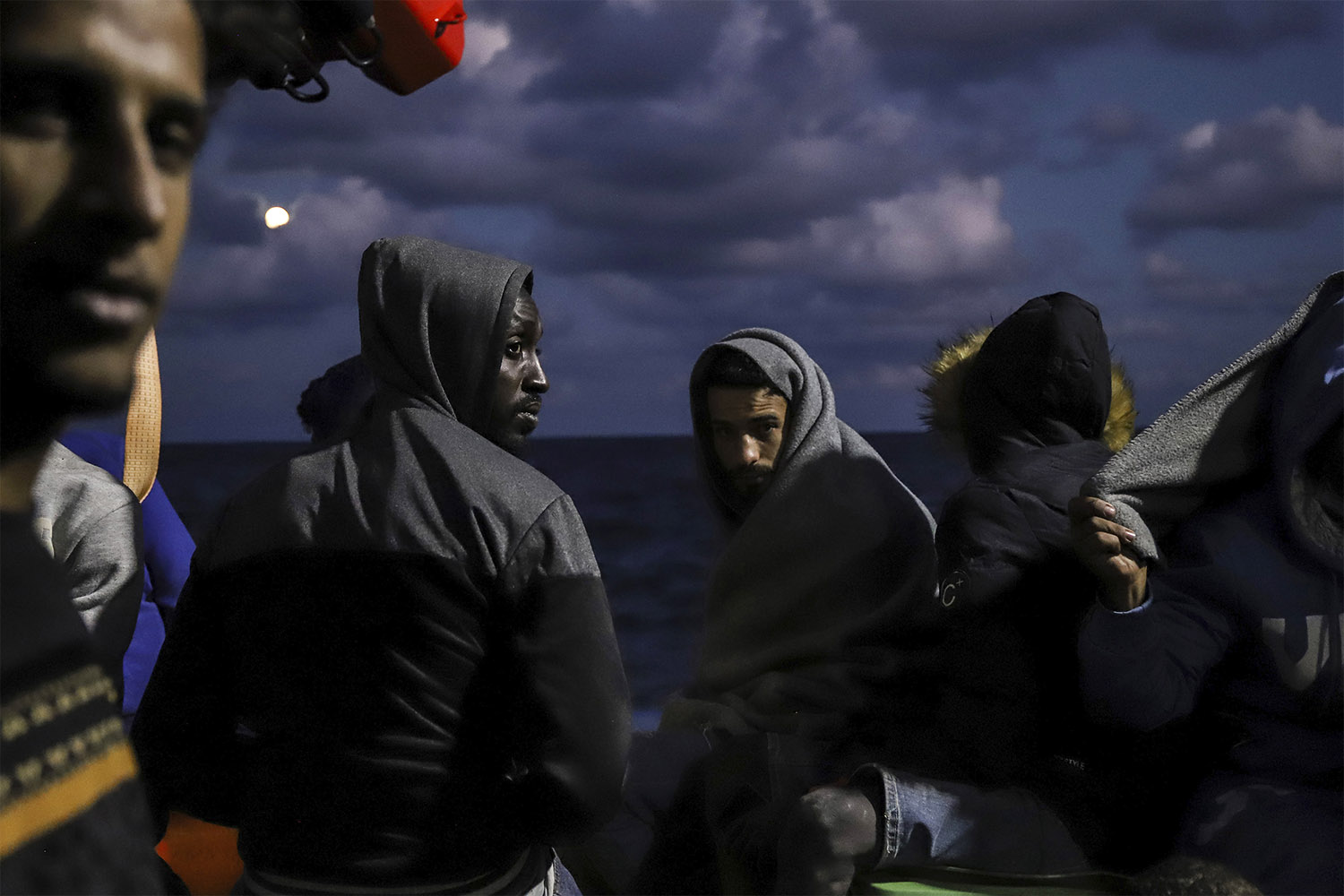 מהגרים יושבים על סיפון ספינת החילוץ Sea Watch-3 באזור החיפוש וההצלה המלטזי של הים התיכון. יומיים קודם לכן חילצה הספינה 412 מהגרים מ-7 סירות שונות במצוקה. 19 באוקטובר 2021 (צילום: AP Photo/Valeria Mongelli)