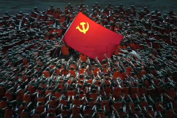 שחקנים לבושים כעובדי הצלה מתאספים סביב דגל המפלגה הקומוניסטית במהלך מופע חגיגי לקראת יום השנה ה-100 להקמת המפלגה הקומוניסטית הסינית בבייג'ינג, ב-28 ביוני 2021. (צילום: AP Photo/Ng Han Guan)