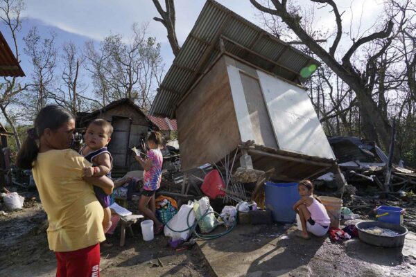 תושבים מחוץ לביתם ההרוס בפיליפינים (צילום: AP Photo/Jay Labra)