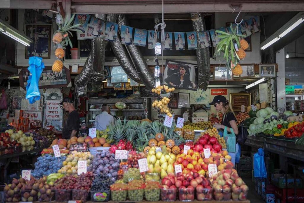 كشك فواكه في سوق الكرمل. من يظهرن في الصورة ليس لهن علاقة في التقرير (تصوير: مريم الستر / فلاش 90)