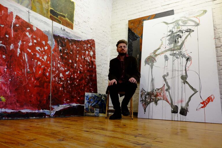 אלכסנדרוביץ' בסטודיו שלו. משמאל: הציור &quot;שערי המלחמה&quot; (צילום: דוד טברסקי)