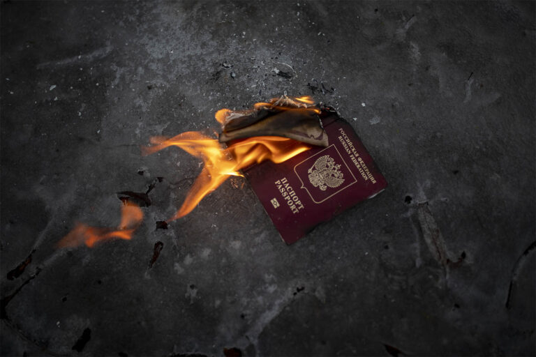 Protesters burn a Russian passport to demonstrates against Russian attacks in Ukraine in front of the Russian embassy in Vilnius, Lithuania, Thursday, Feb. 24, 2022. (Photo: AP Photo/Mindaugas Kulbis)