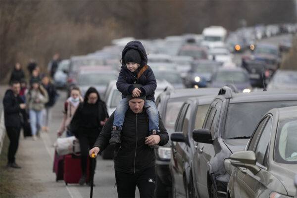 פליטים אוקראינים צועדים ליד שיירת הרכבים שמחכה לחצות את הגבול מאוקראינה למולדובה (צילום: AP Photo/Sergei Grits)