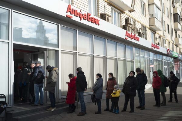 אנשים עומדים בתור למשוך כסף מכספומט של בנק אלפא במוסקבה, רוסיה.(צילום: AP Photo/Victor Berzkin)