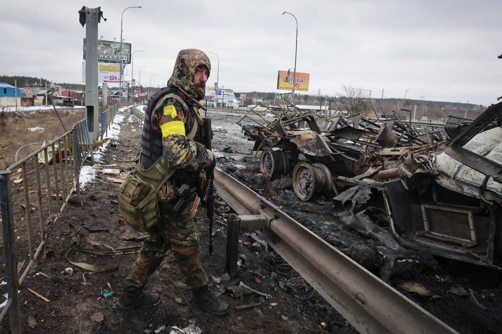 חייל אוקראיני ליד שרידי משוריין רוסי בעיירה בוצ'ה ליד קייב (צילום: AP Photo/Serhii Nuzhnenko)