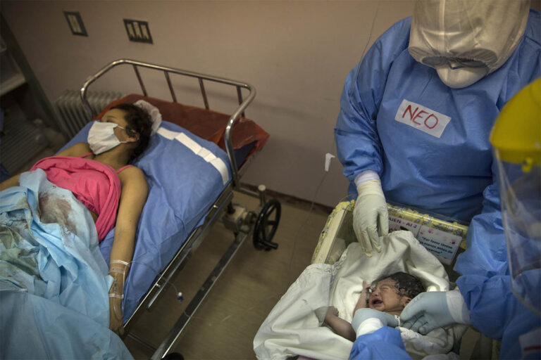 לימה, פרו. רופא בודק תינוקת שזה עתה נולדה לאב שמת מקורונה ולאמא שנדבקה בנגיף, 29 ביולי 2020 (צילום: AP Photo/Rodrigo Abd)