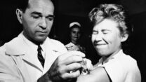 FILE - Dr. Joseph Ballinger giving Marjorie Hill, a nurse at Montefiore Hospital in New York, the first Asian flu vaccine shot to be administered in New York on Aug. 16, 1957. (AP Photo/File)