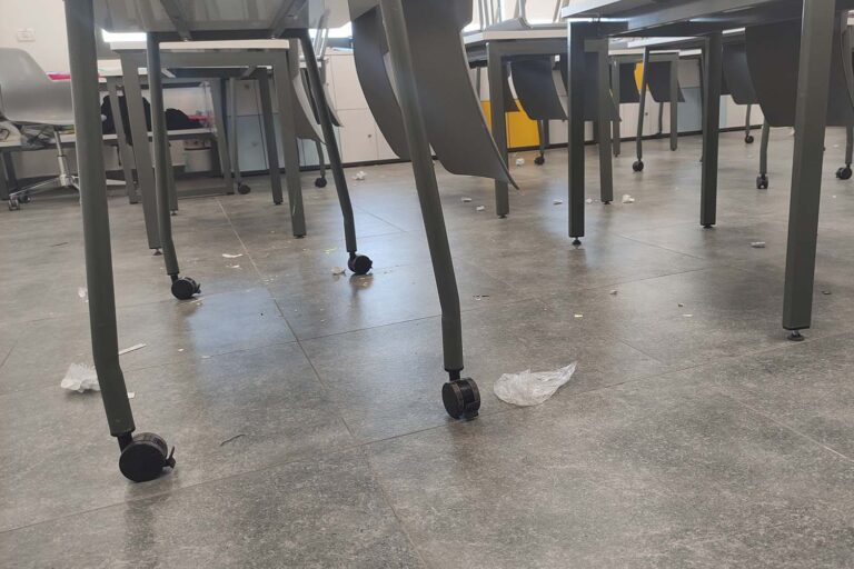 רצפת הכיתה מלאה בקרעי נייר ושאריות. צריך להרים את הכיסאות שהתלמידים לא הרימו (צילום: ניצן צבי כהן)