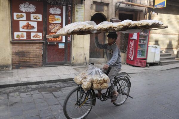 נער מוכר לחם בקהיר. המצרים מסבסדים את מחיר הלחם באמצעות מכירת נכסי מדינה (צילום: AP Photo/Amr Nabil)