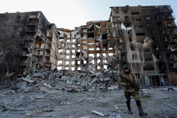 חייל פרו-רוסי ליד בניין דירות שנהרס במריופול (צילום: REUTERS/Alexander Ermochenko)