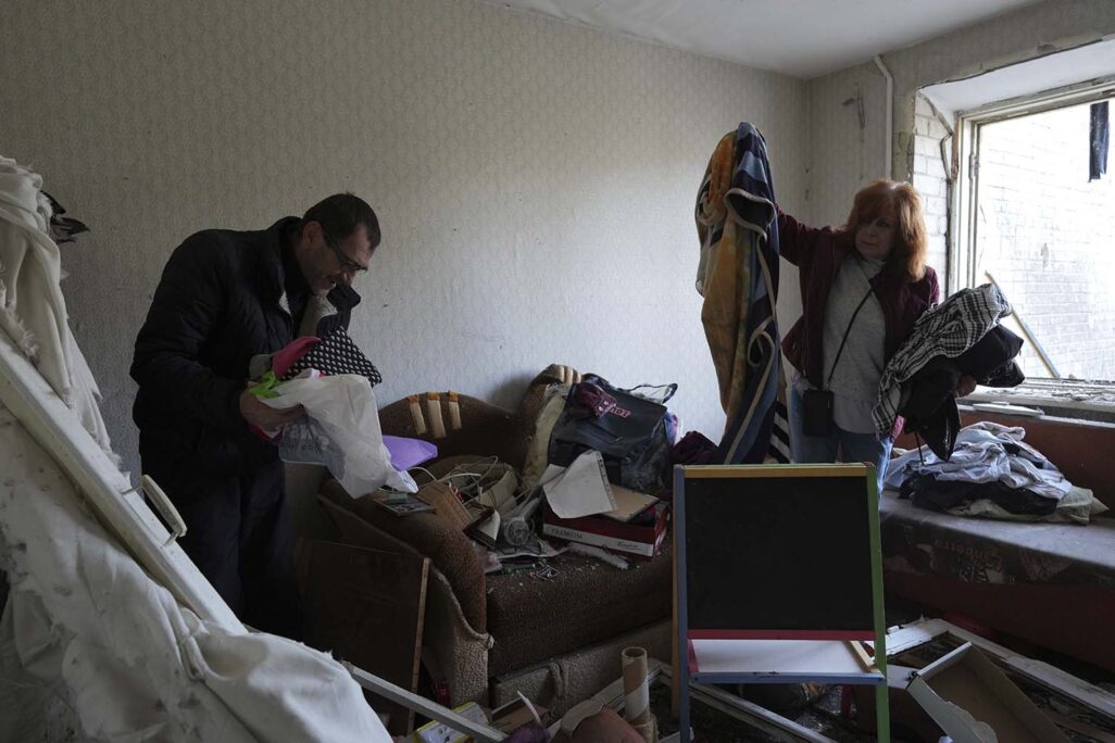 משפחה אוספת ציוד בביתה שהופצץ בצ'רניהיב (צילום: AP Photo/Evgeniy Maloletka)
