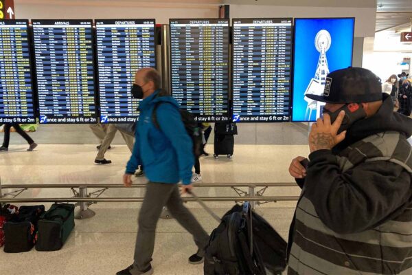 נוסעים עוטים מסכות בנמל התעופה בסיאטל (צילום: טד ס. וורן\סוכנות הידיעות AP)