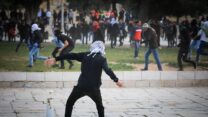 מפגינים פלסטינים זורקים אבנים לעבר כוחות הביטחון הישראליים ברמדאן במתחם מסגד אל-אקצא, אפריל 2022 (צילום ארכיון: ג'מאל עוואד/פלאש 90)