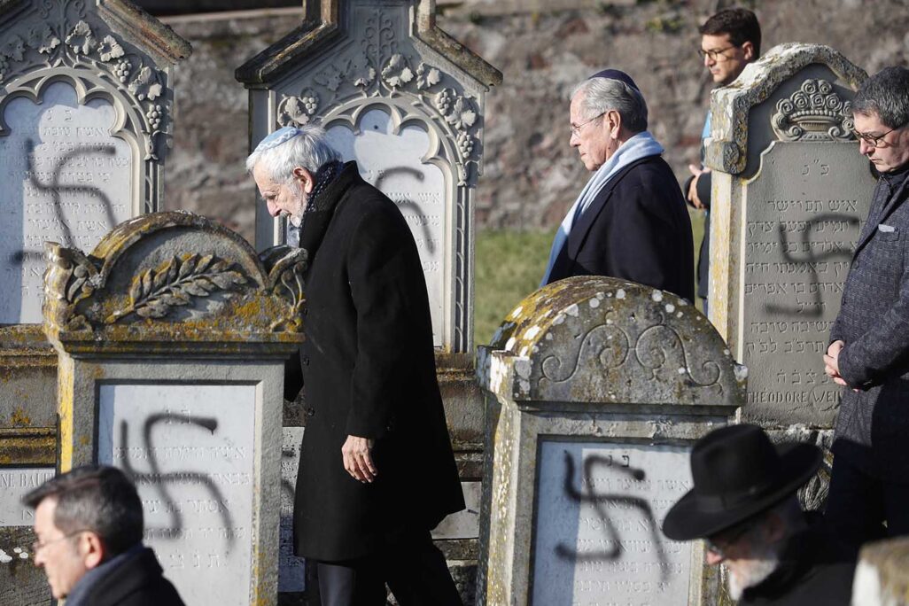 חברים בקהילה היהודית בצרפת מסיירים בבית הקברות היהודי בשטרסבורג, בו רוססו צלבי קרס על מצבות, דצמבר 2018 (צילום ארכיון: AP Photo/Jean-Francois Badias)
