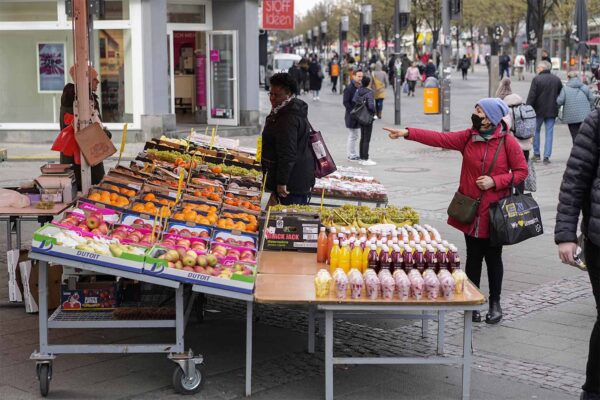 אנשים בוחרים ירקות ופירות בשוק בברלין, אפריל 2022   (AP Photo/Pavel Golovkin)