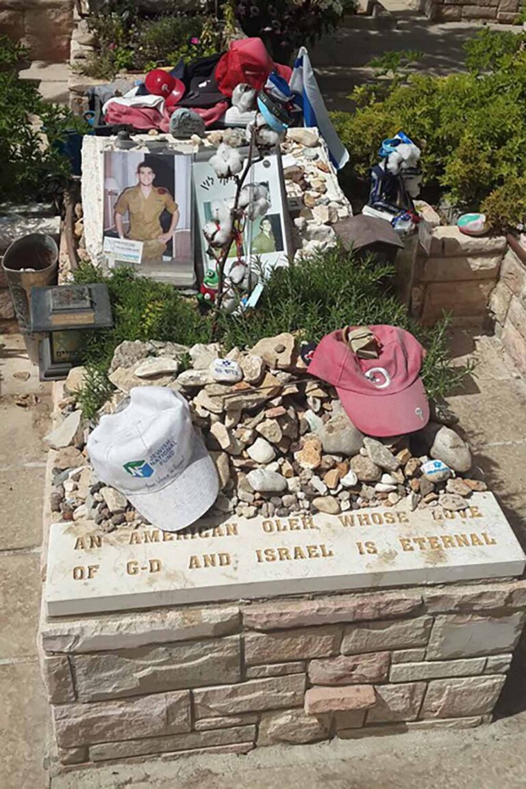 קברו של החייל הבודד מייקל לוין. מזכרות, דגלונים ואבנים מאוירות (צילום: ינון גוטל-קליין)
