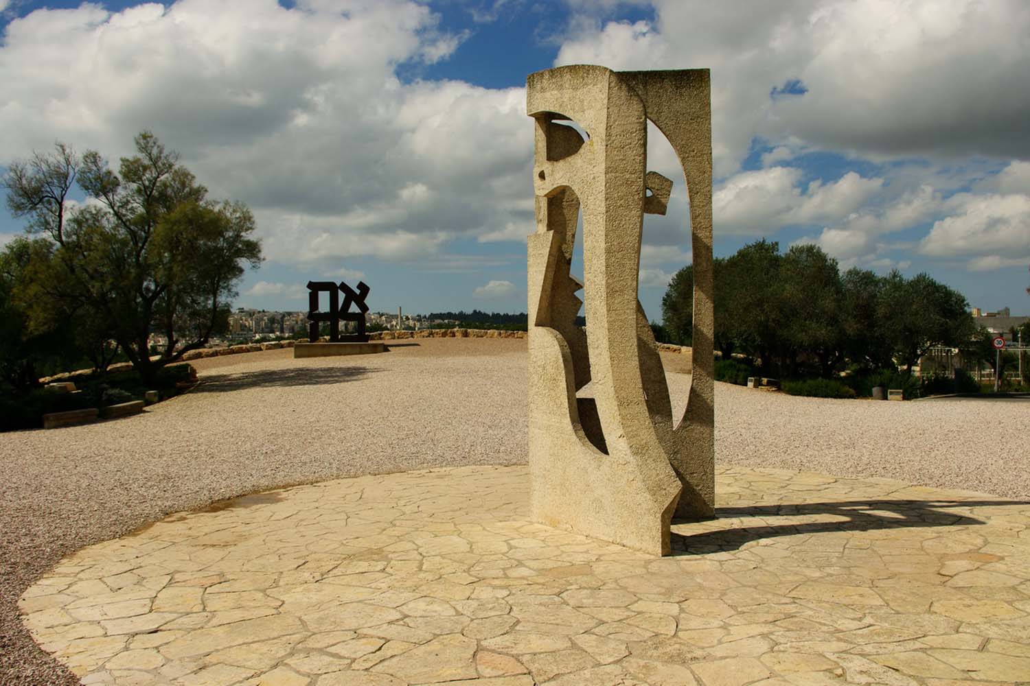 בגן מוזיאון ישראל: פסל של פבלו פיקאסו (מלפנים), ופסל של רוברט אינדיאנה. השבילים עשויים מאבני חצץ (צילום: ויקיפדיה)