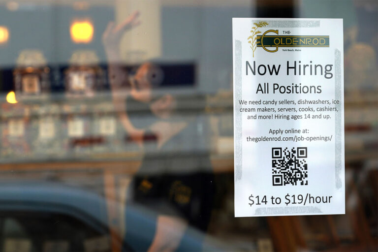 שלט הקורא לגיוס עובדים על חלון ראווה של חנות בארה״ב. שכר המשרות הבלתי מקצועיות זינק לאחר מגפת הקורונה והעלה את תעסוקת בני הנוער (AP Photo/Robert F. Bukaty)