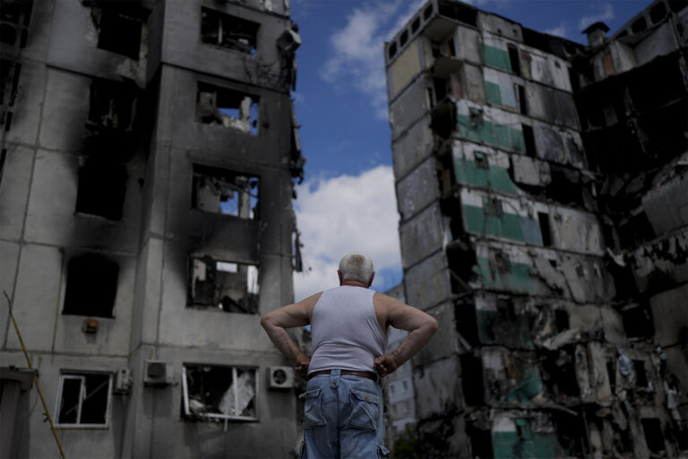 גבר עומד מול הריסות של בניינים שהופגזו בבורודינקה, אוקראינה (צילום: AP Photo/Natacha Pisarenko)