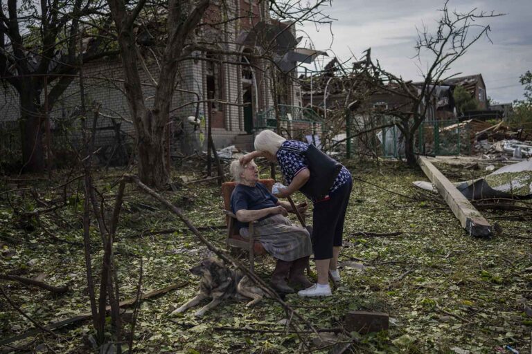 אלנה הולובקו מטופלת כשהיא יושבת מחוץ לביתה, שניזוק מפגיעת טיל רוסי, בדרוז'קובקה שבמזרח אוקראינה (AP Photo/Bernat Armangue)