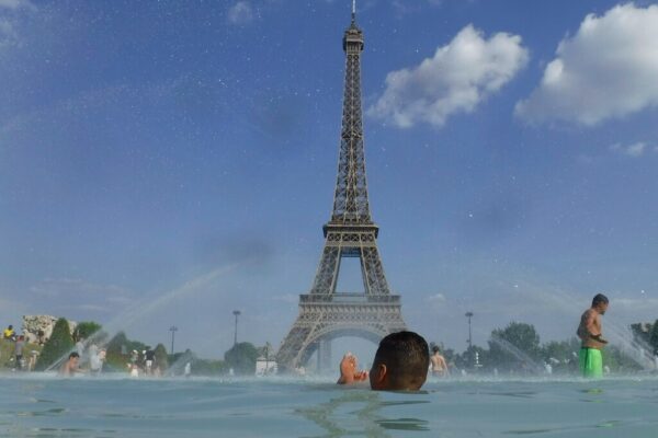 אנשים מתקררים במזרקת הטרוקדרו בפריז, ליד מגדל אייפל (צילום: AP / Alessandra Trentino photo)