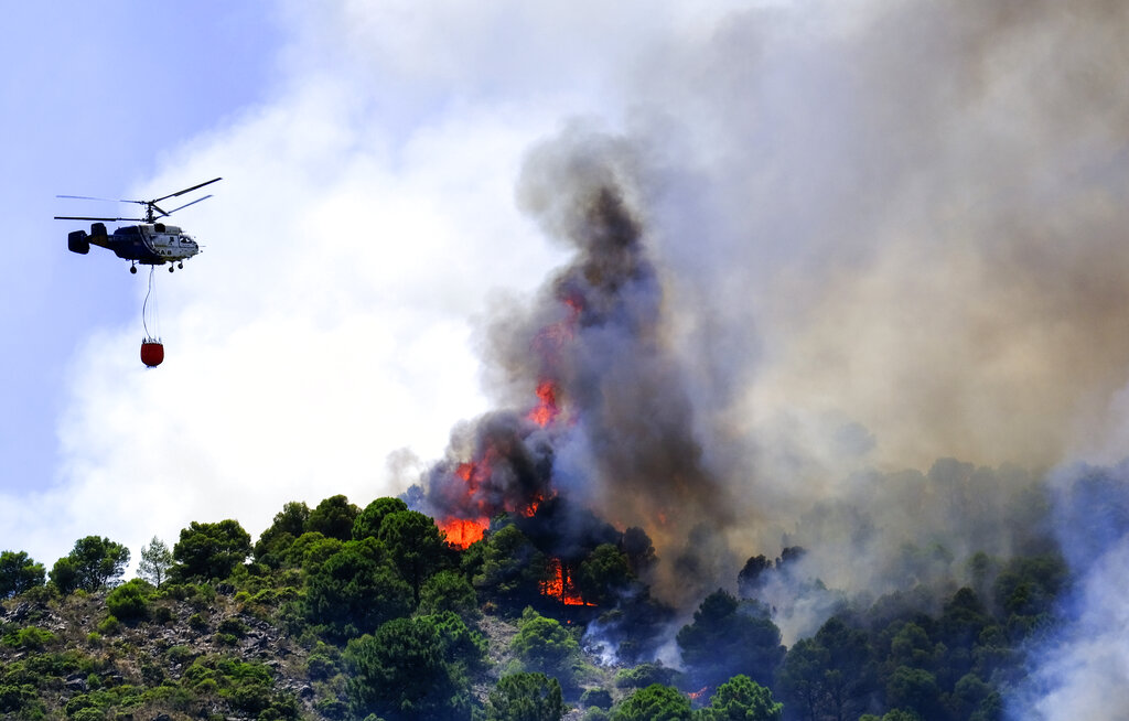 מסוק כיבוי משגר מים לכיבוי שריפה באיזור אלחאורין דה לה טורה במלגה, ספרד במהלך גל חום קיצוני באירופה  (AP Photo/Gregorio Marrero)
