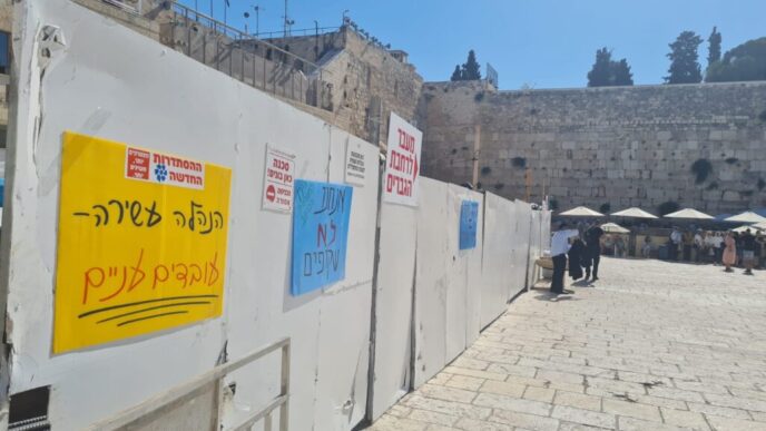Signs next to the Western Wall read "We Are NOT Invisible" and "Rich Management - Poor Workers" (Photo: Western Wall Heritage Foundation Employees' Union)