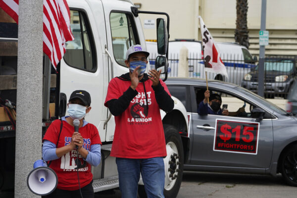 עובדי מקדונלדס ופעילי ארגון 'נאבקים למען ה-15' מפגינים מחוץ לסניף הרשת במזרח לוס אנג'לס, במחאה על פיטוריהם בעקבות תלונות על היעדר הגנה עליהם ממגפת הקורונה ואי תשלום שכר, מרץ 2021 (צילום ארכיון: AP Photo/Damian Dovarganes)