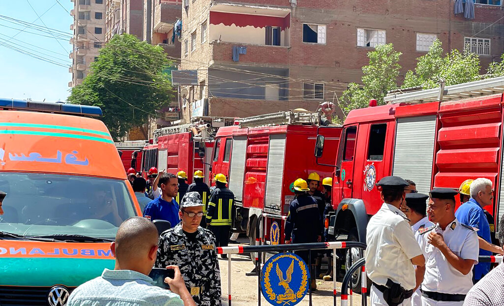 כוחות חירום והצלה מצריים מרחיקים אזרחים מאזור השריפה, ברקע צוותי כבאים נערכים לכיבוי השריפה (צילום: AP Photo/Mohamed Salah)