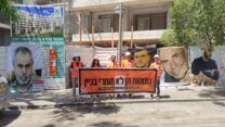 פעילי תנועת מעגלי" צק" באתר הבנייה, ומאחוריהם העובדים שנהרגו השבוע (צילום: ניצן צבי כהן)