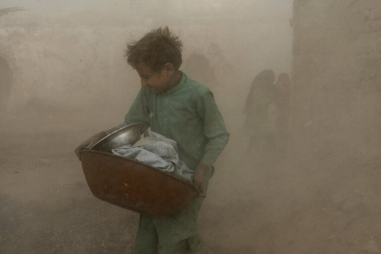 בן 9 נאבק בסופה. &quot;אנחנו רגילים לזה. מהר, בוא נסיים&quot; (צילום: AP Photo/Ebrahim Noroozi)
