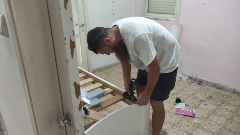 אלישה מרכיב מיטה. "זו לא רק עבודה פיזית, צריך להפעיל את המוח" (צילום: ניצן צבי כהן)