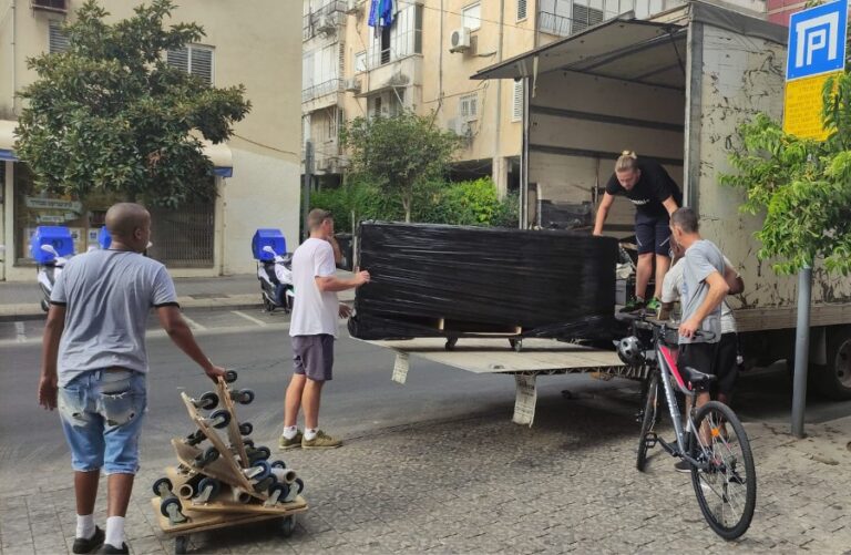הצוות מתחיל להעמיס: תומאש (מימין), מקסים (על המשאית), אלישה ודניאל. אלישה: "לעבוד במשרד היה הורג אותי, אני חייב להוציא אנרגיות" (צילום: ניצן צבי כהן)