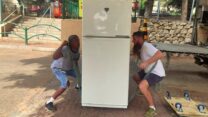 המובילים אורי אלישה (מימין) ודניאל מרימים מקרר בראשון לציון (צילום: ניצן צבי כהן)
