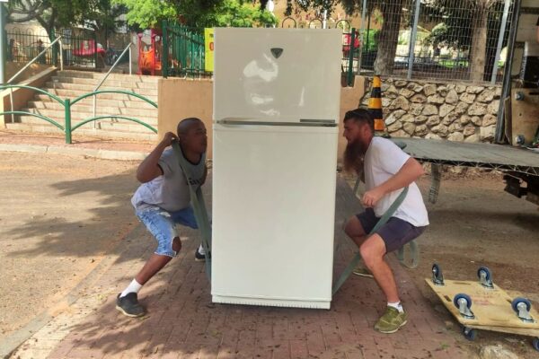 המובילים אורי אלישה (מימין) ודניאל מרימים מקרר בראשון לציון (צילום: ניצן צבי כהן)