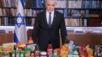 ראש הממשלה יאיר לפיד עם שורת מוצרי המזון שהתקנים עליהם יבוטלו (צילום: ללא קרדיט)