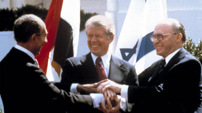 Egyptian President Anwar Sadat, left, U.S. President Jimmy Carter, center, and Israeli Prime Minister Menachem Begin clasp hands on the north lawn of the White House as they completed signing of the peace treaty between Egypt and Israel on March 26, 1979 (AP Photo/Bob Daugherty,File)