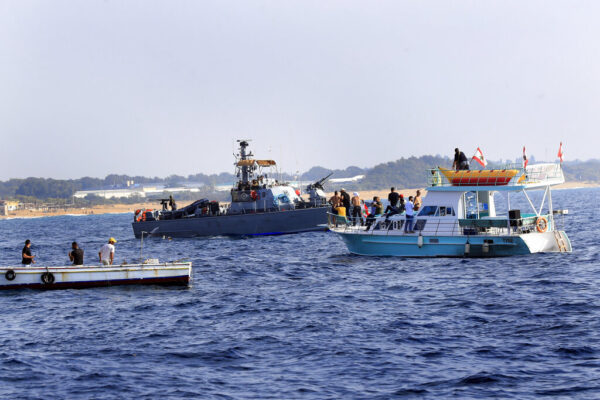 מפגינים לבנונים שטים ליד כלי שיט של חיל הים במהלך מחאה מול שדות הנפט והגז הימיים שלה, בעיירת הגבול הימי הדרומי נקורה (צילום: AP Photo/Mohammed Zaatari)