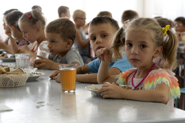 ילדים מבית יתומים במחוז דונצק אוכלים ארוחת בוקר במחנה בזולטויק קוסה, יישוב שסמוך לים אזוב במחוז רוסטוב שבדרום מערב רוסיה (צילום: AP)