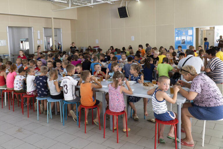 ילדים מבתי יתומים באזור דונצק בארוחת בוקר בחדר האוכל של מחנה היתומים בזולוטיה קוסה. רוסיה מציגה את אקט האימוץ של ילדים אוקראינים כצעד של נדיבות, שמספק בתים חדשים ומשאבים רפואיים לקטינים חסרי ישע (AP Photo)