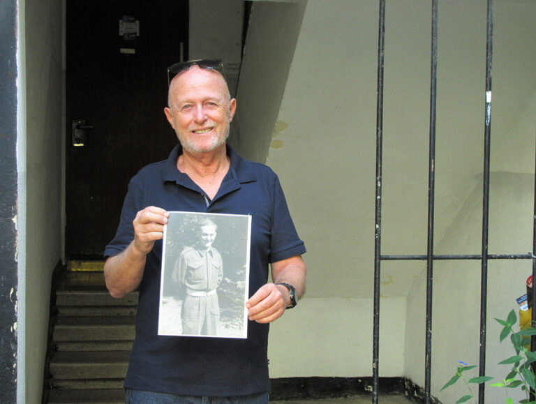 יוסי שמר עם תמונת אביו מקס סמילוביץ בכניסה לביתם בשיכון הבריגדה (צילום: יעל הורוביץ) 