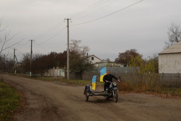 תושב אוקראיני עם דגל בכפר בפאתי חרסון לאחר שחרור העיר (צילום: REUTERS)