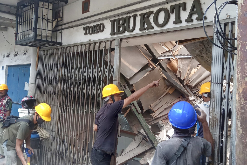 עובדים בוחנים מבנה שהתמוטט לאחר רעידת האדמה בג'אווה אינדונזיה (צילום: AP Photo/Firman Taqur)