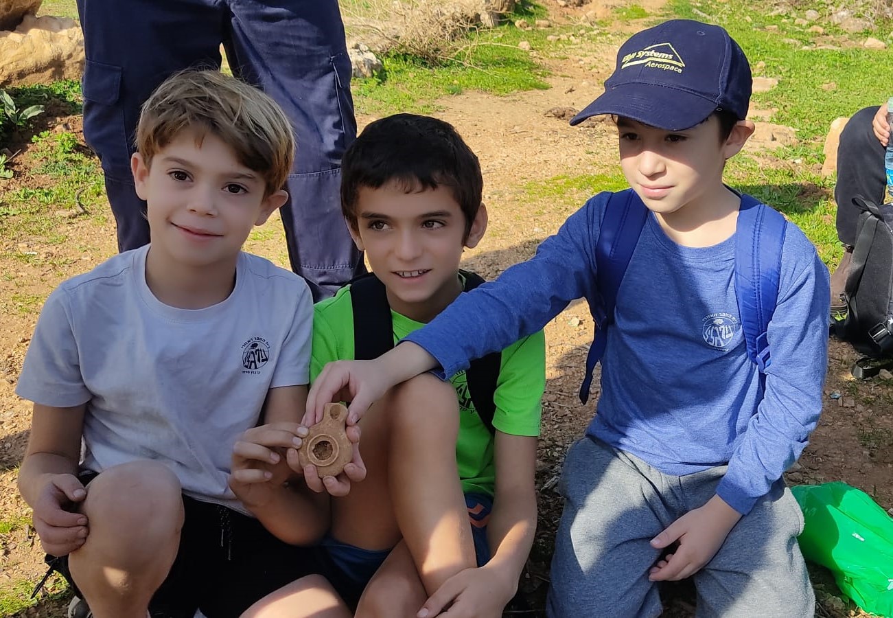 שלושת הילדים: אלון כהן, ליאם אטיאס ורותם לבנת מחזיקים בנר שמצאו (צילום: שלומית אלימור)
