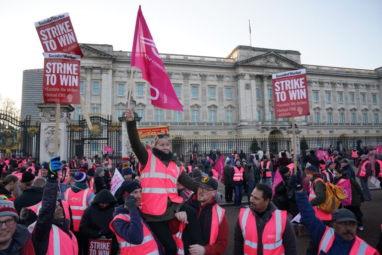 חברי איגוד עובדי התקשורת בבריטניה מחוץ לארמון באקינגהם בהפגנה של עובדי הדואר השובתים במדינה. דצמבר 2022 (PA via Reuters)