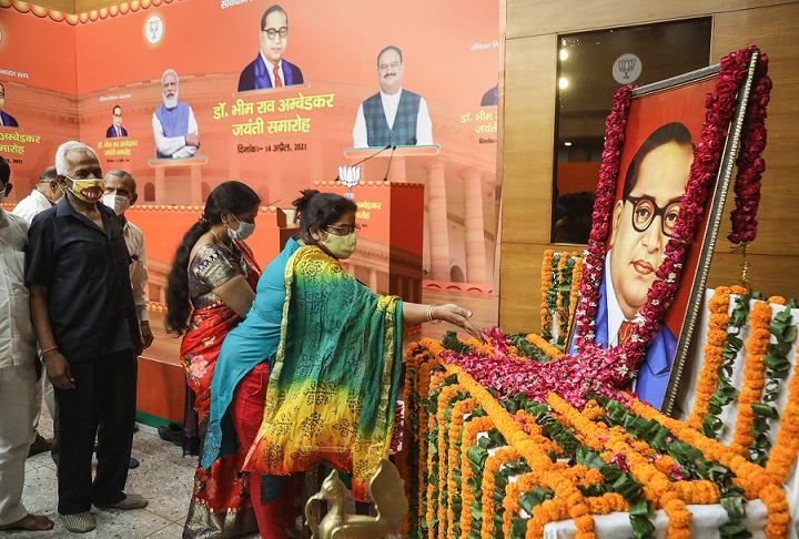 הודים מניחים פרחים על דיוקנו של אמבדקאר, שר המשפטים הראשון של הודו ואבי החוקה ההודית, בטקס לציון 130 שנה להולדתו במטה מפלגת העם ההודית (Naveen Sharma / SOPA Images/Sipa USA)