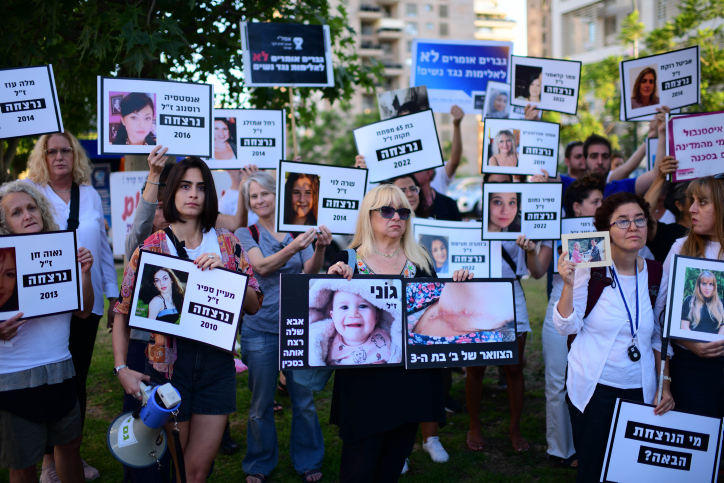 מפגינים אוחזים בשלטים עם תמונות נשים שנרצחו, תל אביב, יוני 2022 (צילום ארכיון: תומר נויברג / פלאש 90)