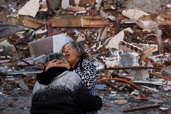 שתי נשים מתחבקות על רקע ההריסות (צילום: REUTERS/Umit Bektas)